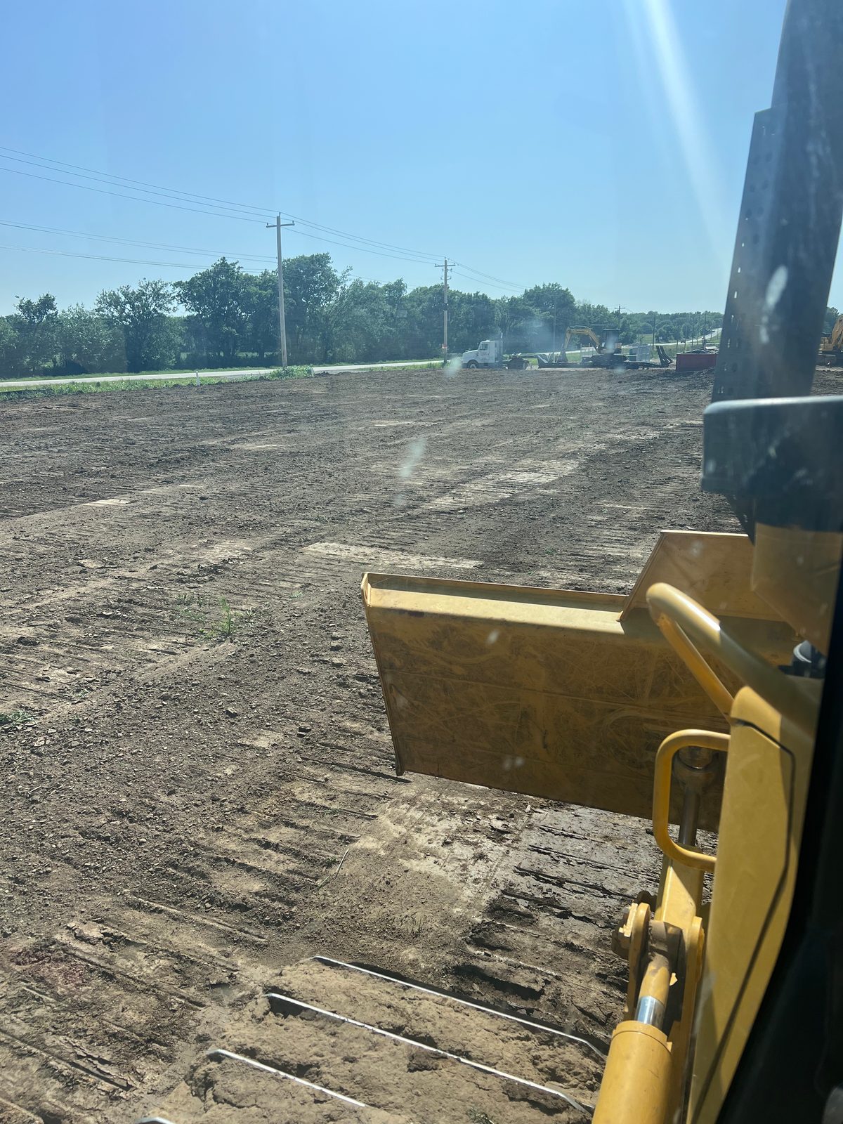 View from a dozer cab clearing and leveling a large commercial pad